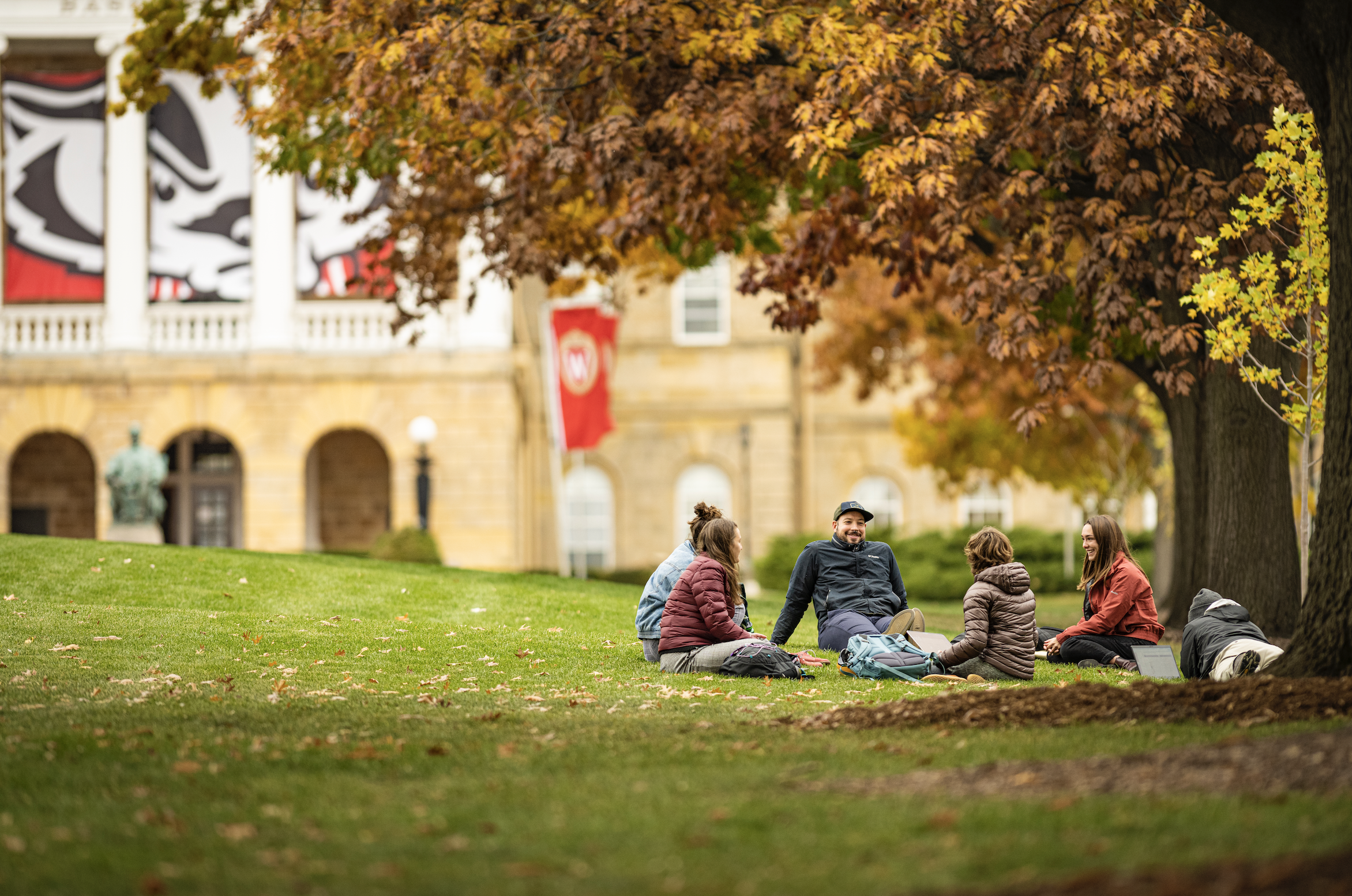 A group of masters students in the Nelson Institute Environmental Conservation program have an informal meeting outside on a warm day among the colors of the fall leaves on Bascom Hill at the University of Wisconsin-Madison during autumn on November 10, 2021. (Photo by Bryce Richter / UW-Madison)